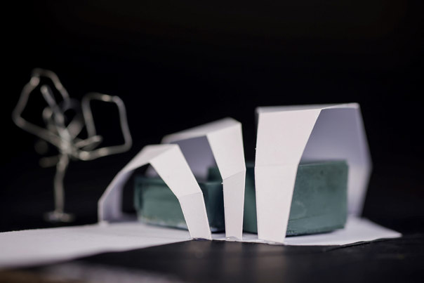 Close-up view of an angular architectural model, featuring white arches.