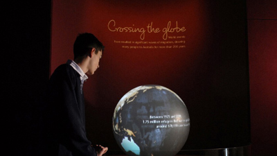  Student looking at the globe in the Leaving Home gallery