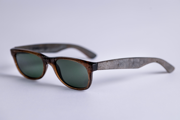 Pair of vintage-style sunglasses with brown frame and green-tinted lenses.