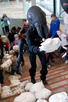 A worker ant and children carry bread crumb replicas.