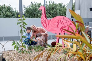 Boy and his mother near a large pink emu cut out in the Gandel Gondwana Garden