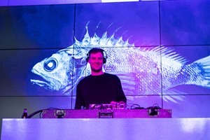 A DJ smiling for the camera at Nocturnal, Melbourne Museum.