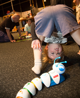  Upside-down Child playing with a Code-a-pillar in the Energy Lab during the Little Kids Day In.