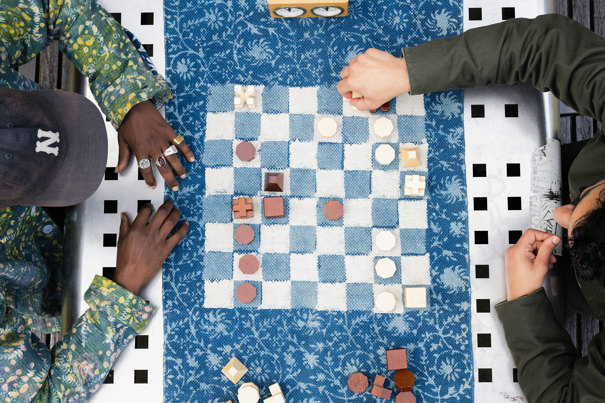 A birds-eye view of a cloth chessboad played by Maleik Njoroge and an opponent in the park.