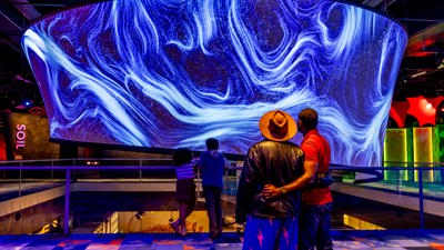 A family look at the large cylindrical projection centerpiece in Our Wondrous Planet at Melbourne Museum.