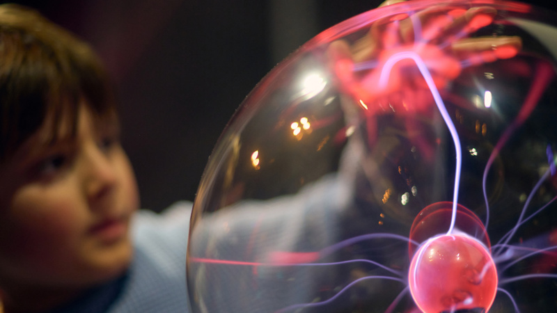 A child touches a lightning-touch plasma ball