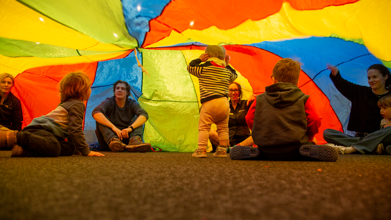 Children playing under a parachute at Scienceworks.