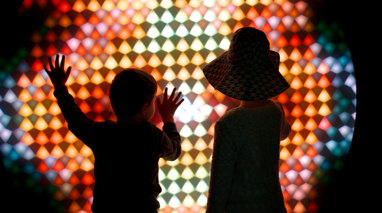 Children with facing a bright colourful light wall. 